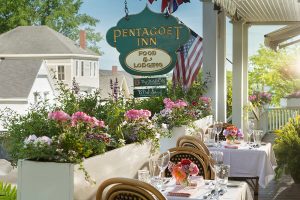 Front porch sign and tables at Pentagoet Inn